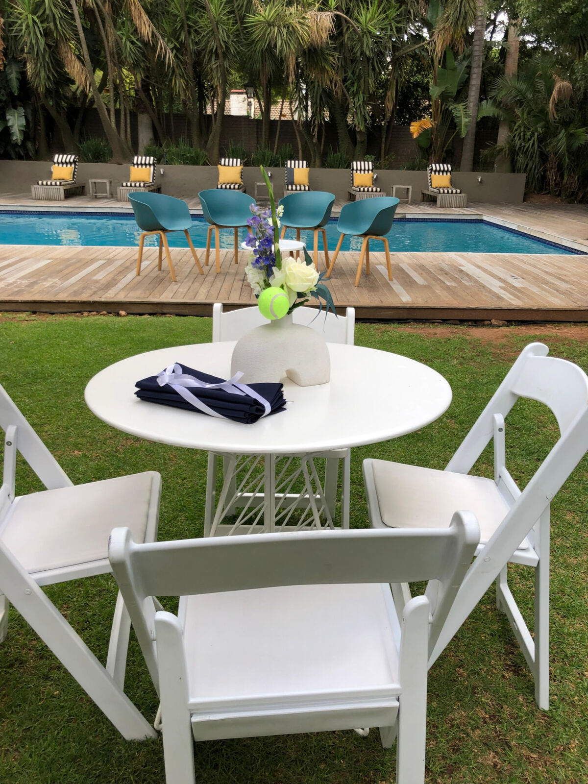 Poolside tables and lounge seating set up for a tennis themed brand activation