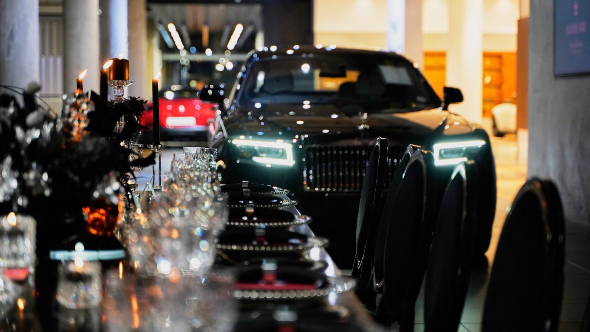 Candlelit dinner table set beside a vehicle at a product launch